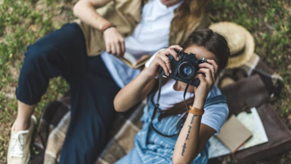 A photo of a woman resting in the open and taking a photograph