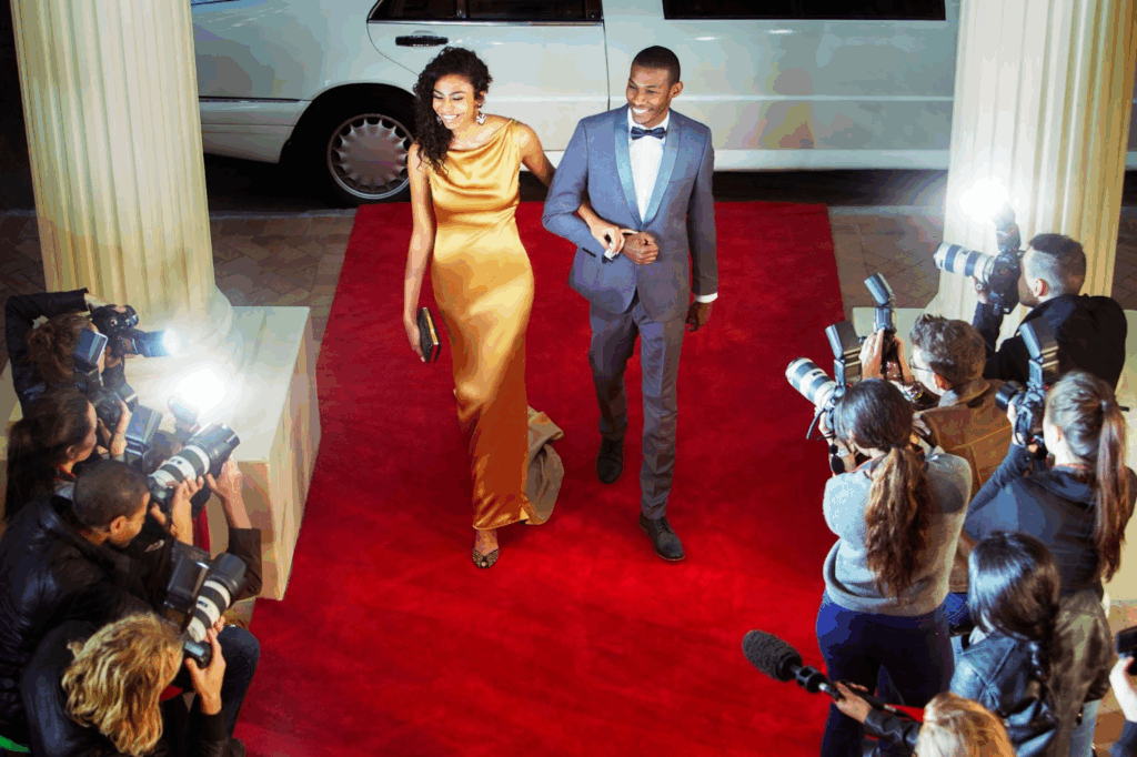 Two celebrities with criminal records showing up to a red carpet event in a black suit and yellow ball gown.